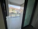 Balcony view of a residential building with glass railing and tile flooring