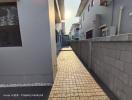 Paved walkway alongside modern residential buildings with a view of the sunset