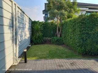 Well-maintained garden adjacent to a residential home with lush greenery and paved area