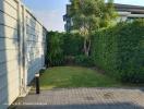 Well-maintained garden adjacent to a residential home with lush greenery and paved area
