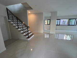 Spacious well-lit living area with staircase