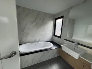 Modern bathroom with marble tiles, bathtub and sink