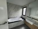 Modern bathroom with marble tiles, bathtub and sink