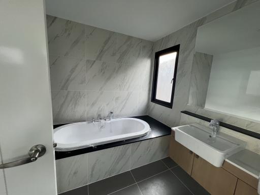 Modern bathroom with marble tiles, bathtub and sink