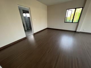 Spacious unfurnished bedroom with hardwood floors and ample natural light