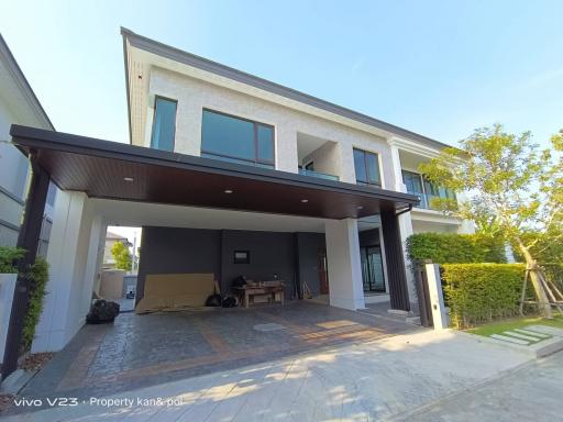 Modern two-story house with spacious carport and lush green lawn