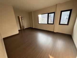 Spacious unfurnished room with large windows and hardwood flooring