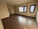 Spacious unfurnished room with large windows and hardwood flooring