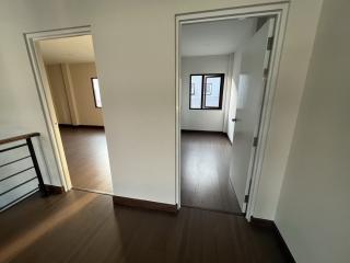 View of a well-lit hallway with open doors leading to adjacent rooms