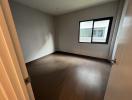 Empty bedroom with wooden flooring and natural light