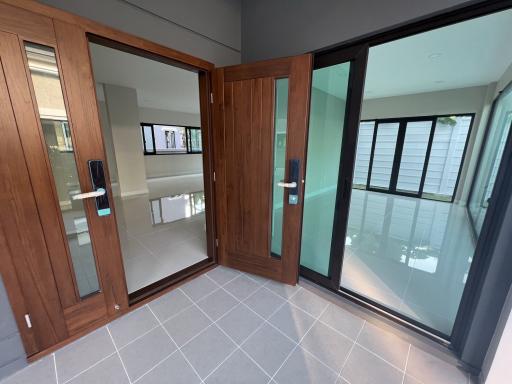 Modern home entrance with wooden door and tiled floor