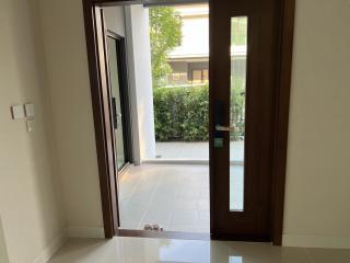 View from the open entrance door of a home showing the interior hallway and a glimpse of the exterior