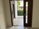 View from the open entrance door of a home showing the interior hallway and a glimpse of the exterior