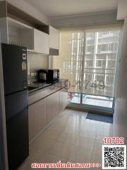 Modern kitchen with stainless steel appliances and large windows