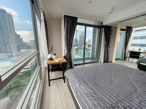 Spacious bedroom with large windows and city view