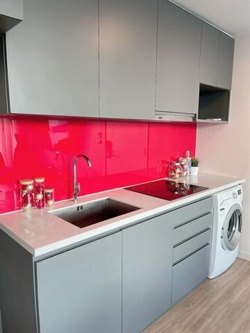 Modern kitchen with red backsplash and stainless steel appliances