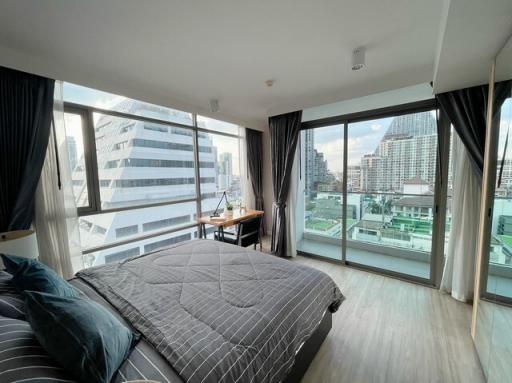 Spacious bedroom with floor-to-ceiling windows and city view