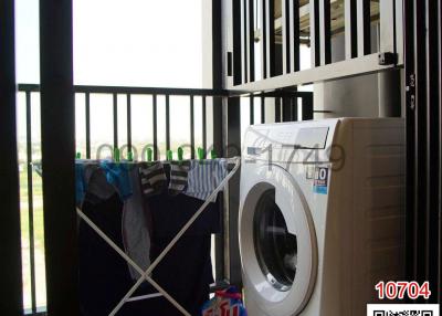 Laundry area with washing machine and drying rack behind security bars