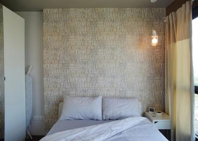 Cozy bedroom with a travel-themed wallpaper and natural light