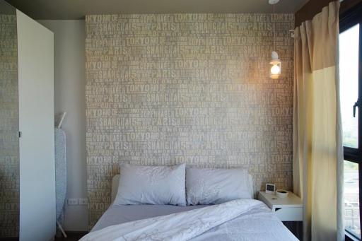 Cozy bedroom with a travel-themed wallpaper and natural light