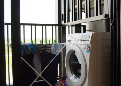 Compact indoor laundry area with washing machine and drying rack