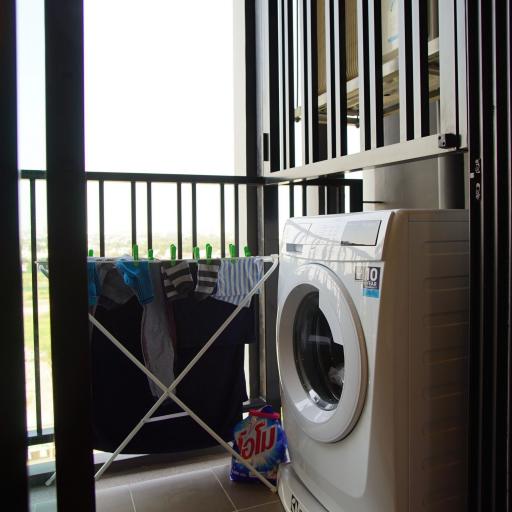 Compact indoor laundry area with washing machine and drying rack