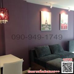 Elegant living room interior with violet walls, modern chandelier, comfortable sofa, and Paris-themed wall art