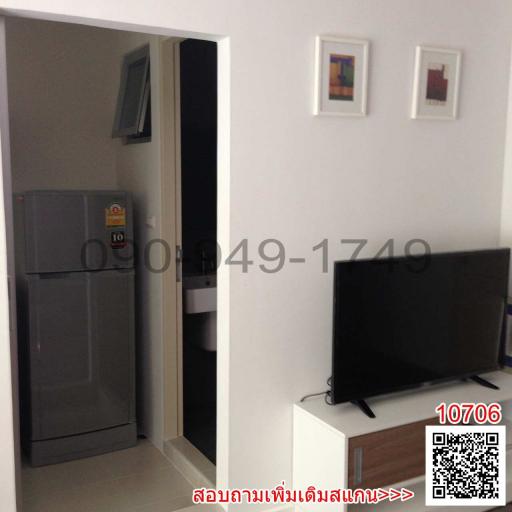 Compact living area with modern television and refrigerator