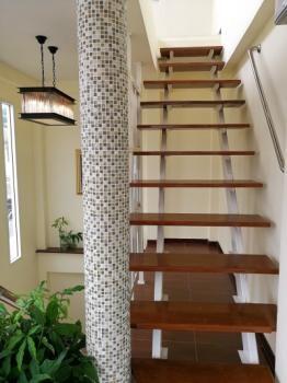 Elegant staircase with wooden steps and decorative tiled column in a modern home