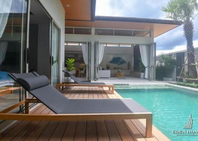 Modern home with pool and lounge chairs on wooden deck