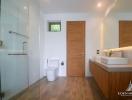 Modern bathroom with glass shower enclosure and wooden cabinets