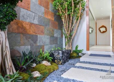 Modern house entrance with stone path and decorative wall