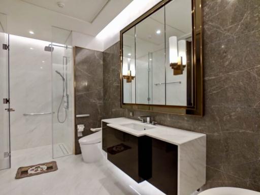 Modern bathroom with marble tiles, large mirror, and glass shower