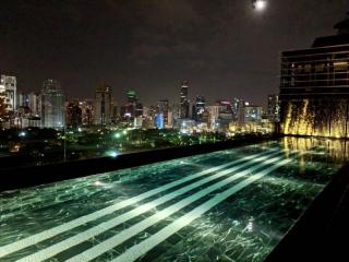 Luxurious rooftop pool with city skyline view at night