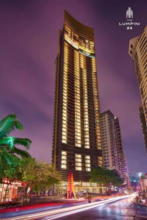 High-rise residential tower at dusk with illuminated windows