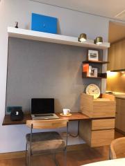 Compact home office space with integrated shelving, modern decor, and kitchenette