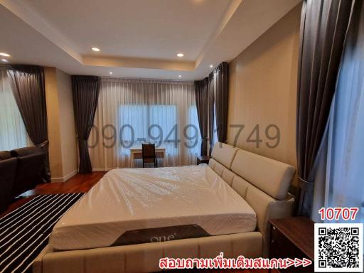 Spacious bedroom with large bed, hardwood floors and natural lighting