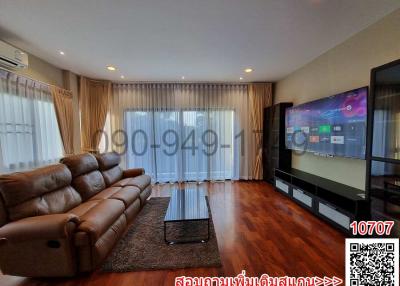 Spacious living room with large sofa and modern TV