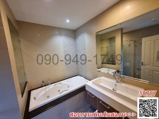 Spacious modern bathroom with jacuzzi and dual vanity