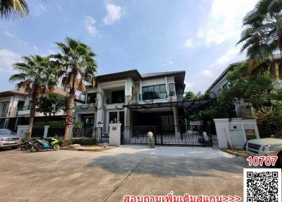 Modern two-story house with balcony and gated driveway