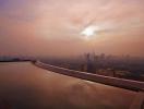 Rooftop view of a city skyline at sunset with an infinity pool