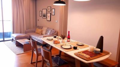 Modern dining room with set table and an adjacent living area