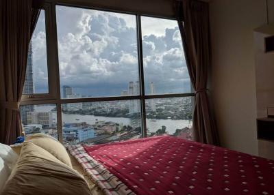Bedroom with a large window providing a panoramic city view