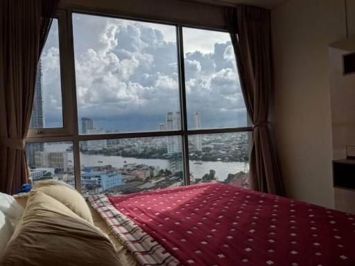 Bedroom with a large window providing a panoramic city view