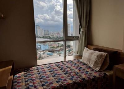Cozy bedroom with a city view from a high-rise apartment