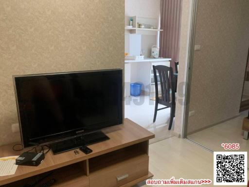 Modern living room interior with television and dining area in the background