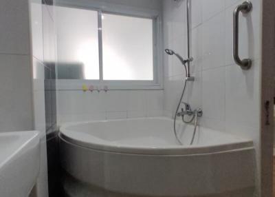 Modern bathroom with corner bathtub and glass partition