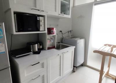 Modern compact kitchen with white cabinetry and appliances