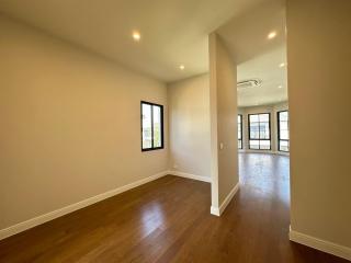 Spacious empty room with hardwood floors and ample natural light