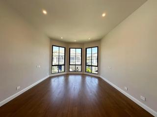 Spacious bedroom with hardwood floors and large windows